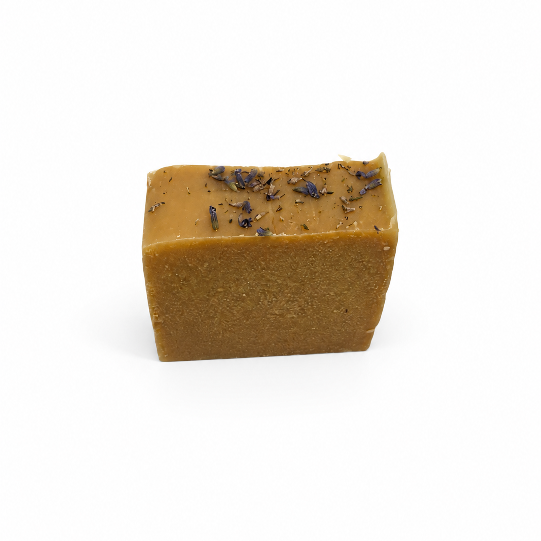 Square bar of soap with visible ingredients on a white background