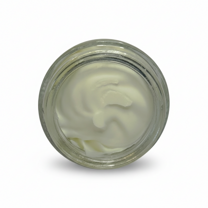 Clear glass jar with white cream-like substance on a gray background