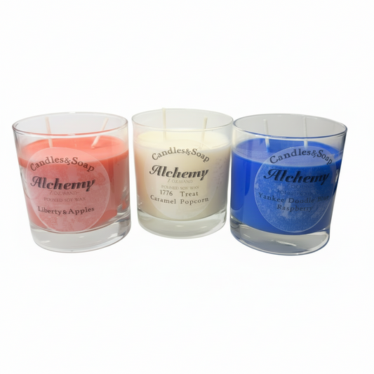 Three glass candles with labels on a white surface